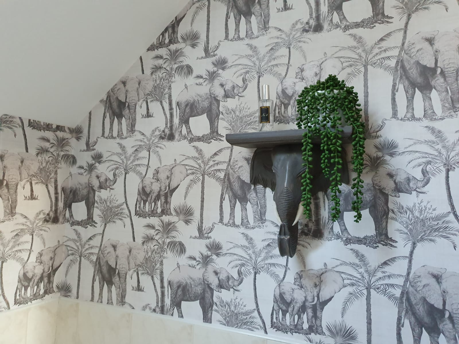 Bathroom feature wall with elephant and palm wallpaper, painted shelf and elephant head decoration. Wallpapering by Local Painter and Decorators Sheffield.