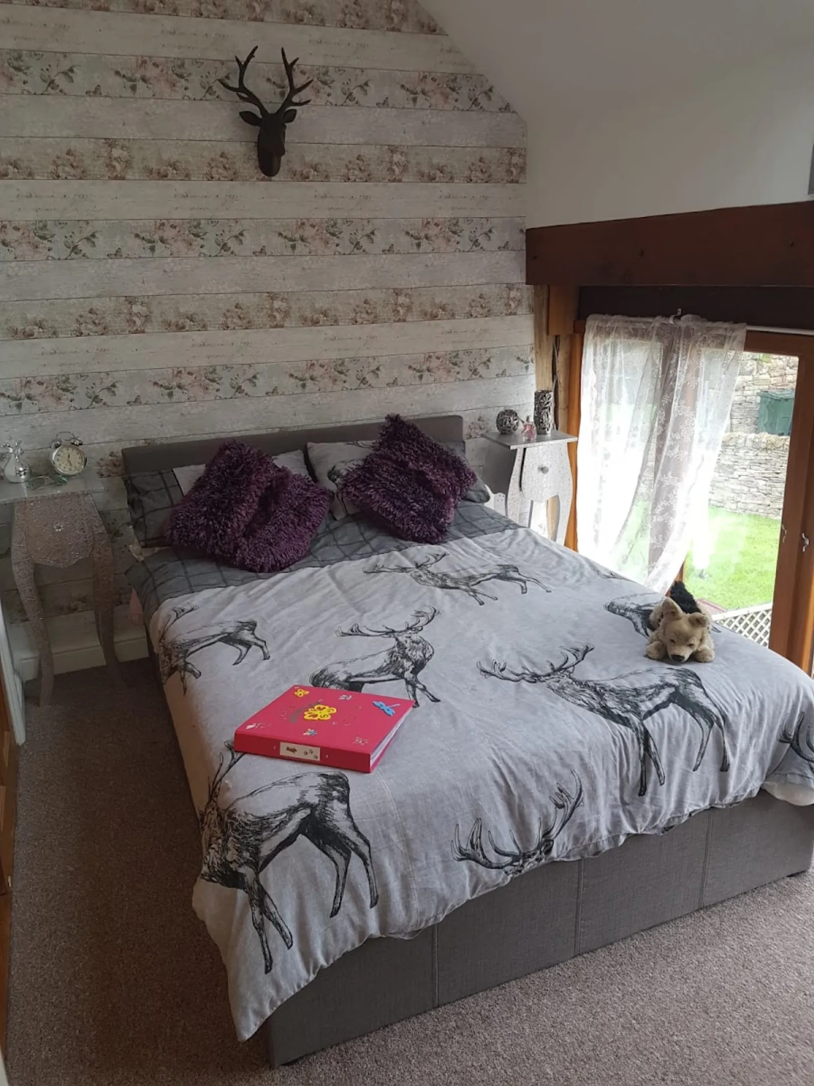 Bedroom with stag duvet and matching stripe-and-stag wallpaper, painted woodwork and grey carpet. Decorating by Richard Walton, Sheffield.