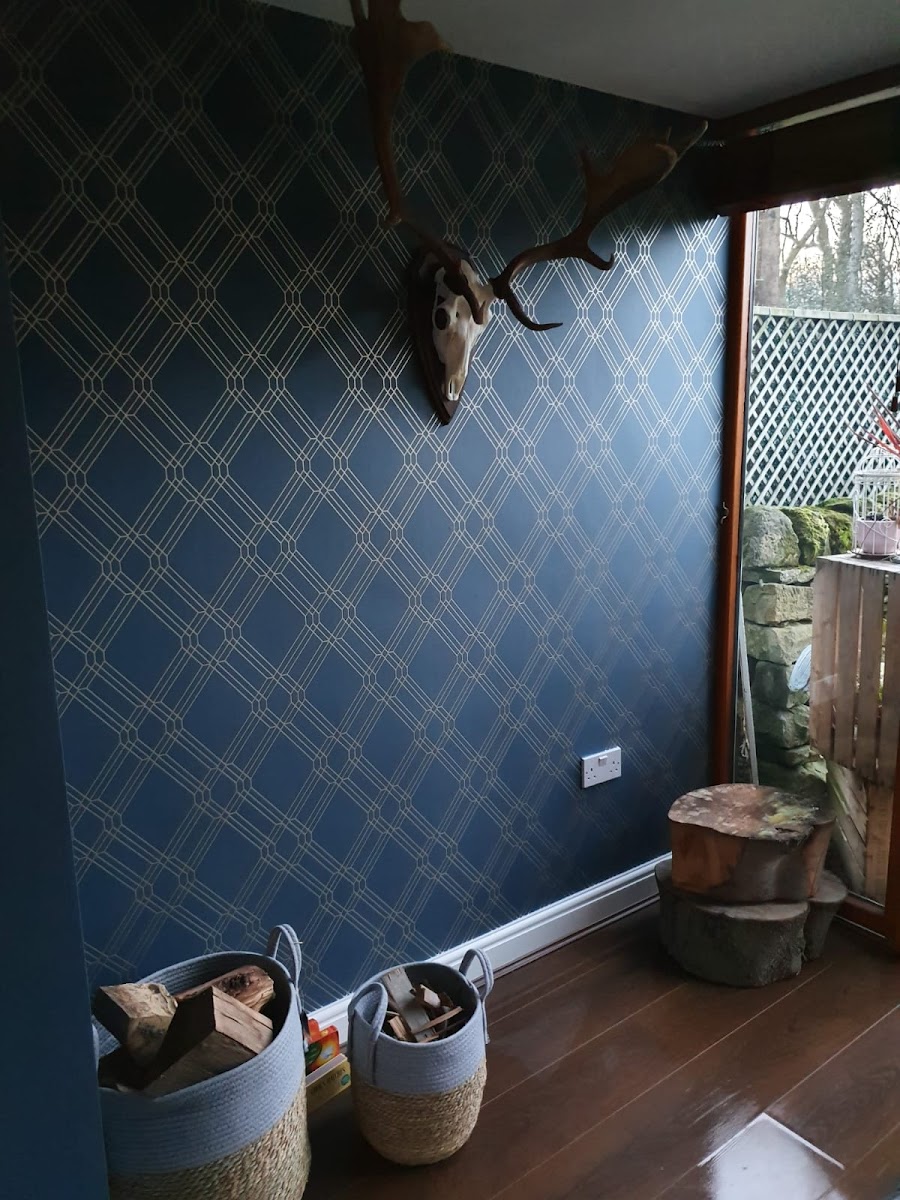 Hallway with deep navy geometric wallpaper, log basket, antlers, painted skirting and oak floor. Decorating by Local Painter and Decorators Sheffield Hillsborough.